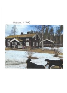 Fotografi av et hovedhus med grønt tak og en mindre bygning i bakgrunnen, tatt i vinterforhold med snø på bakken.