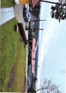 Fotografi av en bolig med hage, kjøretøy og nabolag.