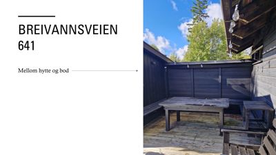 Fotografi av en uteplass med bord og benker foran en mørk hytte eller bod.