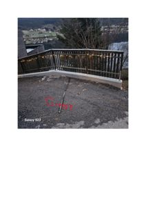 Fotografi av en terrasse eller balkong med en hekk, lyskeder og utsikt over et vassdrag. Bildet viser en eksisterende eller ferdigstilt del av en bygning.