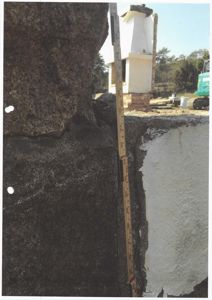 Fotografi av en murvegg med en målebånd som viser høyde, sannsynligvis for dokumentasjon av skade eller konstruksjon.