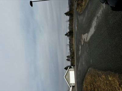 Fotografi av en vei og en bolig sett fra siden.