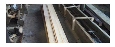 Fotografi av byggplass eller lager med trekonstruksjoner og armering.