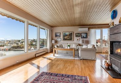 Fotografi av et innredet stueområde med utsikt over vann og by.