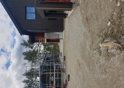 Fotografi av en bygning under oppføring eller renovering, med en del av fasaden og etasjer synlig.