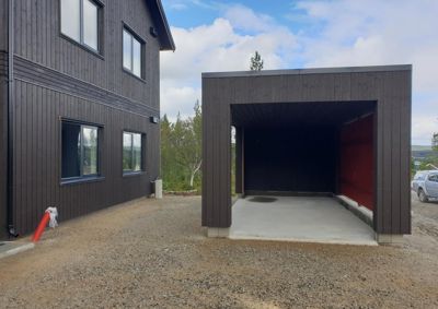 Fotografi av en nybygd bolig med en tilhørende garasje, sett fra utsiden.