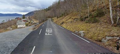 Fotografi av en vei (F-150) med nabolag og fjell i bakgrunnen.