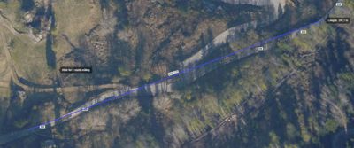 Satellittbilde (flyfoto) av et terreng med en markert linje (Forskriftsveien) og målepunkter.