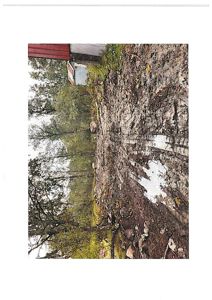 Fotografi av en tomte med en delvis ferdig bygning i bakgrunnen.