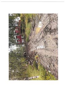 Fotografi av et bygge- eller grunngrovt område med en rød bygning i bakgrunnen.