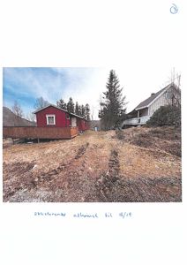 Fotografi av eksisterende atkomst til eiendom med en rød hytte og en hvit bygning i bakgrunnen.