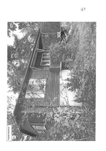 Fotografi av en eksisterende eller planlagt hytte sett fra siden, med omgivende vegetasjon.