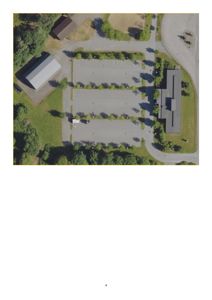 Luftfoto (flyfoto) av en tomt med bygninger og parkeringsplasser.