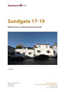 Fotografi av en hvit, trepanelert bygning med flere vinduer og et tak, sett fra gaten. Det er også synlig en bil parkert foran bygningen.
