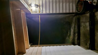 Fotografi av en trapp og en utvendig veggmur, sannsynligvis tatt under eller etter en byggeprosess.