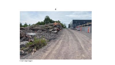 Fotografi av et byggefelt med grusvei, steinhuggeri og en del av en nybygg (bygg 14 og 15) i bakgrunnen.