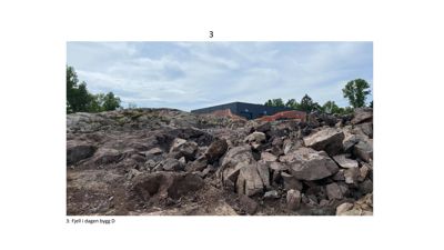 Fotografi av et byggefelt med fjell i forgrunnen og en mørk bygning i bakgrunnen.