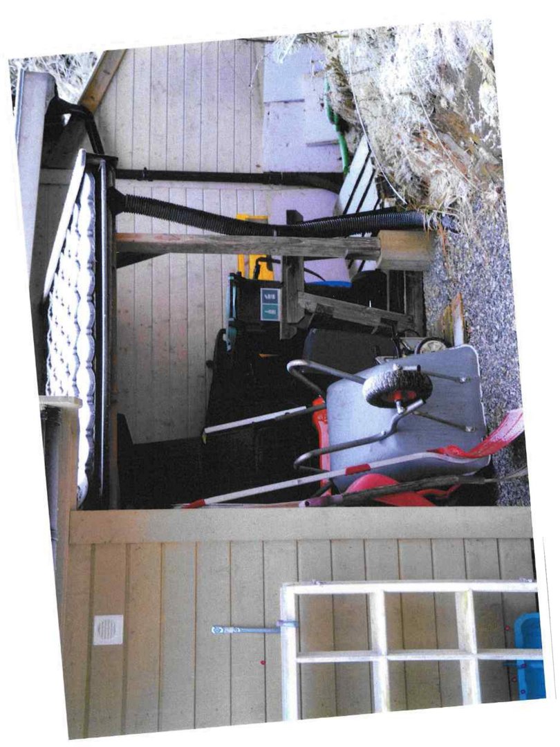 Fotografi av en bygning sett fra siden, med synlig fasade, vindu, takrenne og utstyr under bygningen.