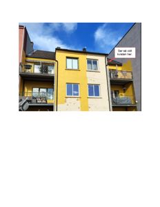 Fotografi av en gule fasade på en bygning med balkonger og vinduer, sett fra nede mot toppen.