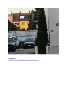 Fotografi av en gateløp med parkerte biler og en gul bygning i bakgrunnen med et merket takvindu.