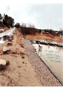 Fotografi av en eksisterende eller planlagt anleggsdel (muligens en VA-ledning langs kanten av et vann) med håndskrevne notater om hvordan ledningen skal legges.