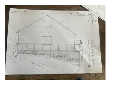 Håndtegnet fasadetegning (oppriss) av en bygning med angitte mål, vinduer og planlagt isolering.