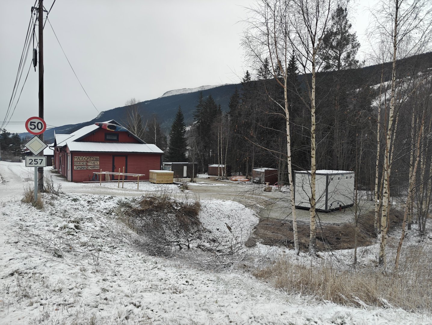 Fotografi av en rød bygning og omgivelser i et snødekt landskap.