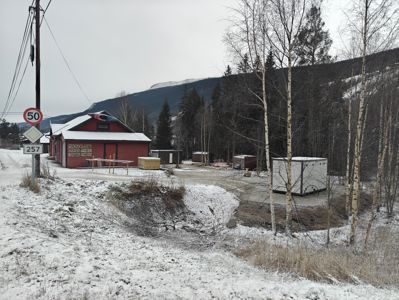Fotografi av en rød bygning og omgivelser i et snødekt landskap.