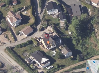 Luftfoto av et boligområde med flere hus og veier, inkludert en liten kartinnsats i nederste høyre hjørne.