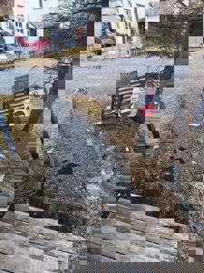 Fotografi av en privat vei med en 'Privat vei' skilt, et forbudsskilt for innkjøring, og en del av en bygning i bakgrunnen.