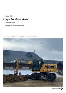 Fotografi av en guleggevogn (gruvebagger) foran en bygning med skrått tak, sannsynligvis på byggeplass for 'Nye Sør-Fron skule'.