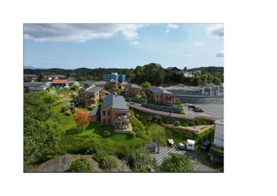 Fotografi av et boligområde med flere hus, en vei, parkeringsplass og vann i bakgrunnen.