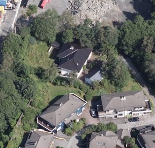 Luftfoto (satellittbilde) av en boligbebyggelse med flere hus, trær og veier.