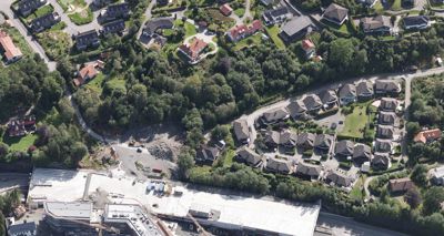 Luftfoto av et boligområde med en byggeplass i forgrunnen.