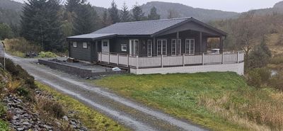 Fotografi av en ferdig eller nesten ferdig bygget hytte sett fra utsiden.