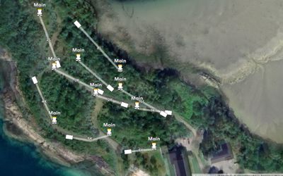 Satellittbilde (kart) som viser et kystområde med skog, en vei og flere markerte punkter (hvorav noen er merket 'Main').