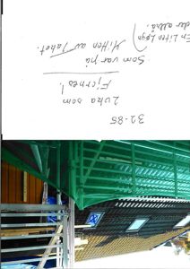 Fotografi av en bygning under arbeid, med grønn takduk og stålkonstruksjon synlig.