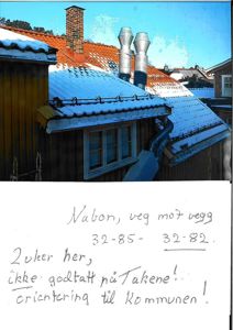 Fotografi av en bygning med snø på taket og en håndskrevet notat under.