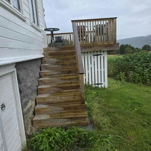 Fotografi av en utvendig trapp og en terrasse ved siden av en hvit bygning.