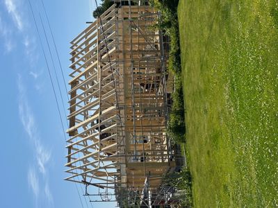 Fotografi av en bygning under oppføring, der det er synlig trekonstruksjon og stålrammer.