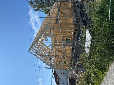 Fotografi av en bygning under oppføring med synlig tømmerkonstruksjon og stålramme.